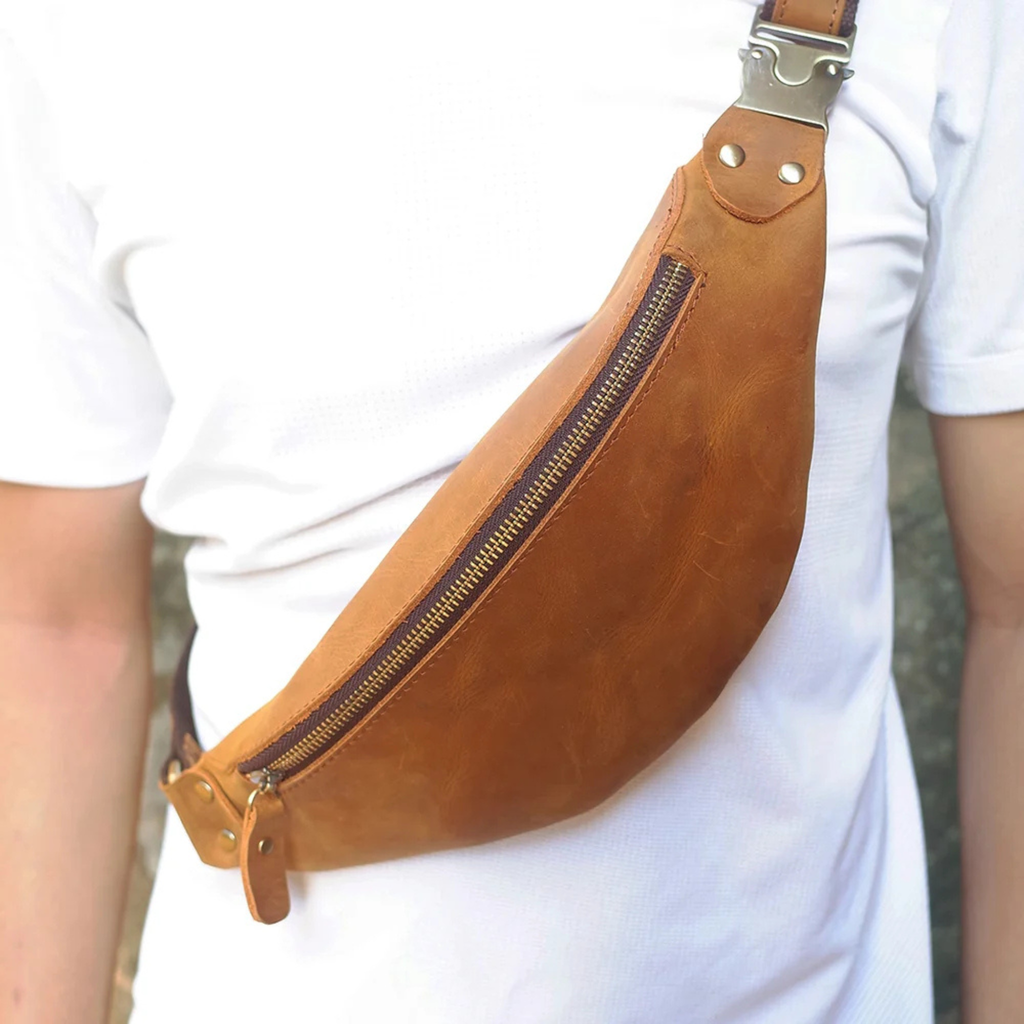 Tan leather crossbody waist bag worn over the shoulder