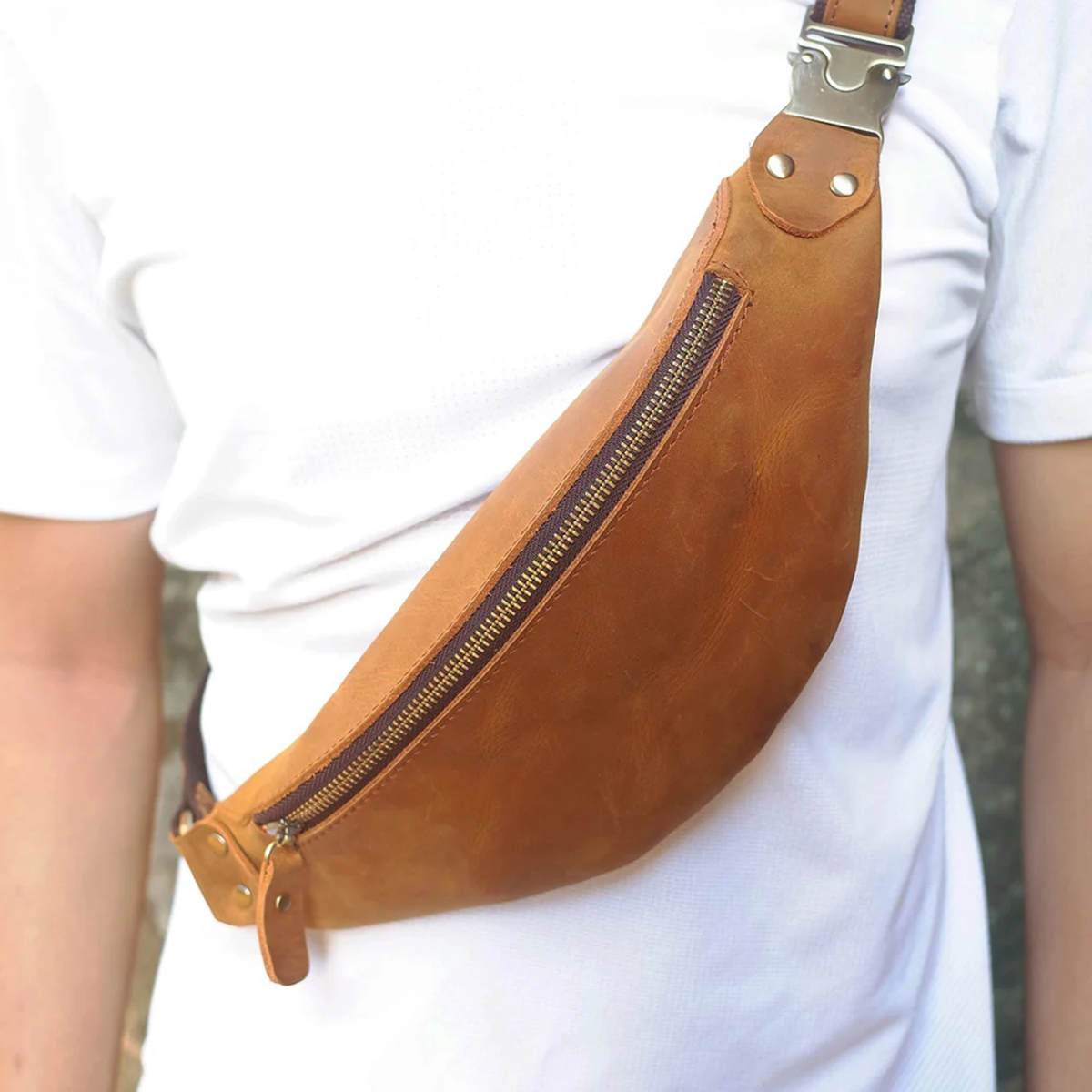 Tan leather crossbody waist bag worn over the shoulder